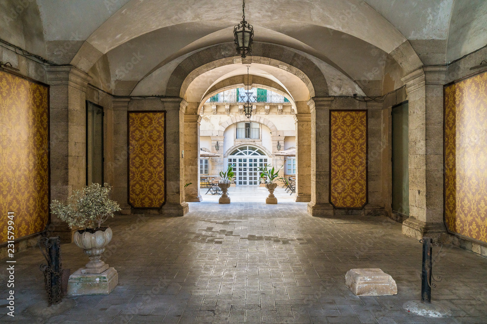 A cozy and elegant entrance in an historic palace of Siracusa old town (Ortigia). Sicily, southern Italy.