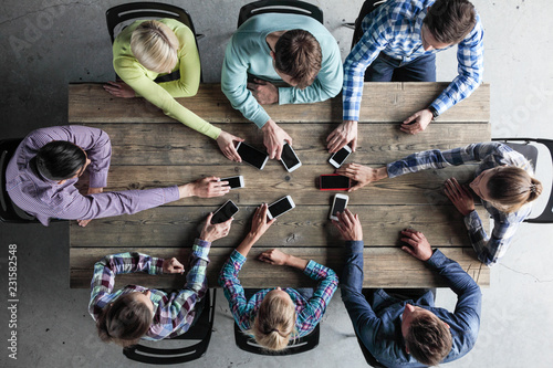 Team of people put smartphones to table photo