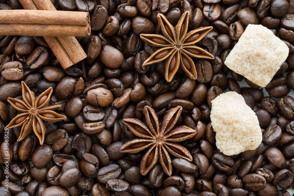 cinnmon sticks, bronw sugar and anise stars on coffee beans background. cinnmon sticks, bronw sugar and anise stars on coffee beans background.