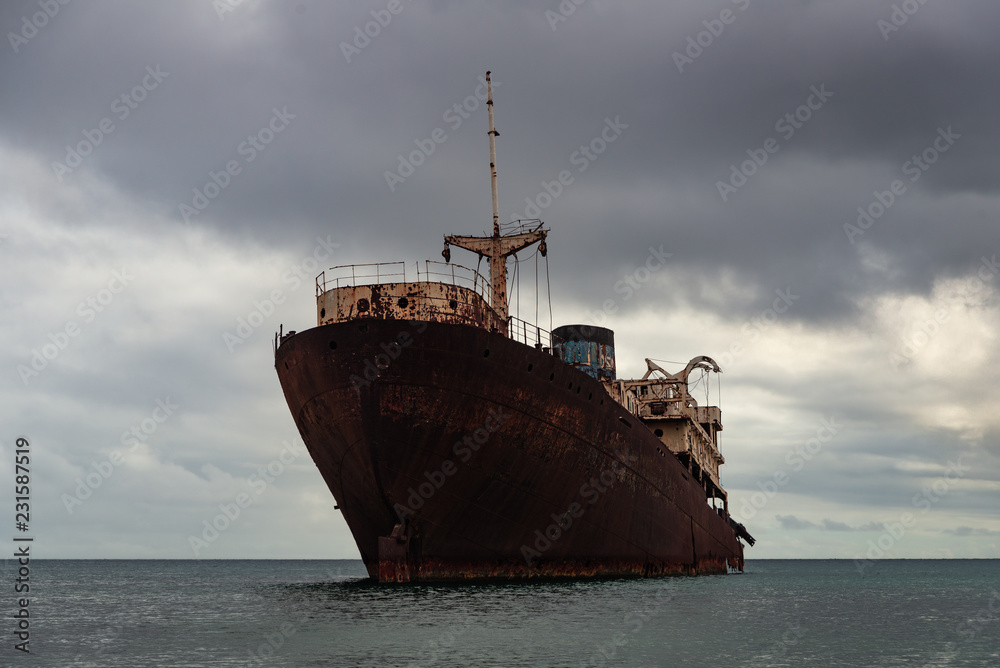 rusty cruiser in the ocean under a grim leaden sky rusty cruiser in the ocean under a grim leaden sky
