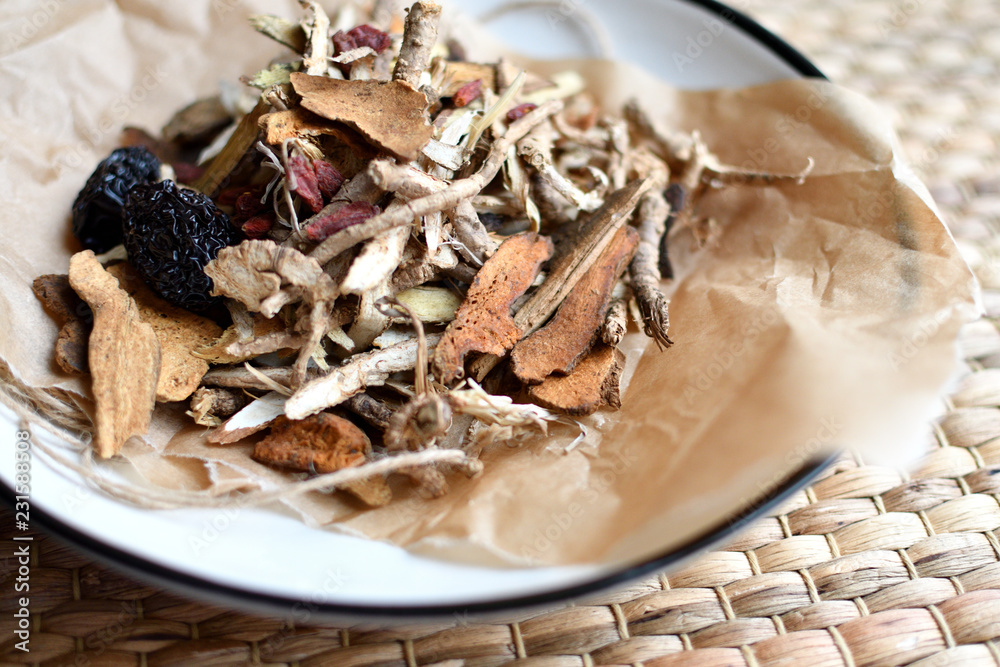 Chinese traditional medicine script. Herbal tea with jujubes, goji berries, gingseng roots and others on parchment paper on neutral background. Chinese traditional medicine script. Herbal tea with jujubes, goji berries, gingseng roots and others on parchment paper on neutral background.
