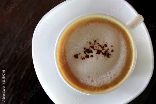 hot cappuccino coffee on wooden table