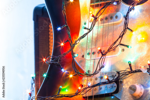 Electric guitar in bright colors of festive lights of the garland