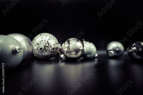 Elegant greyscale Christmas baubles on black.