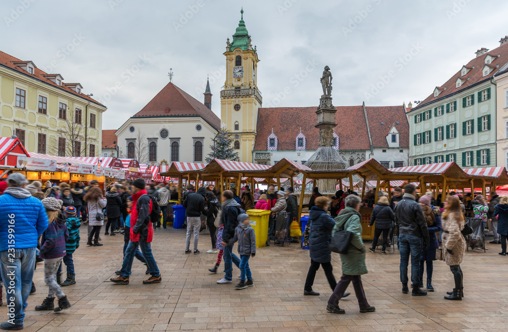 Obraz na płótnie View on Christmas market on the Main square in Bratislava,Slovakia. Stara radnica and Bratislava Christmas Market, blurred people can be seen. w salonie