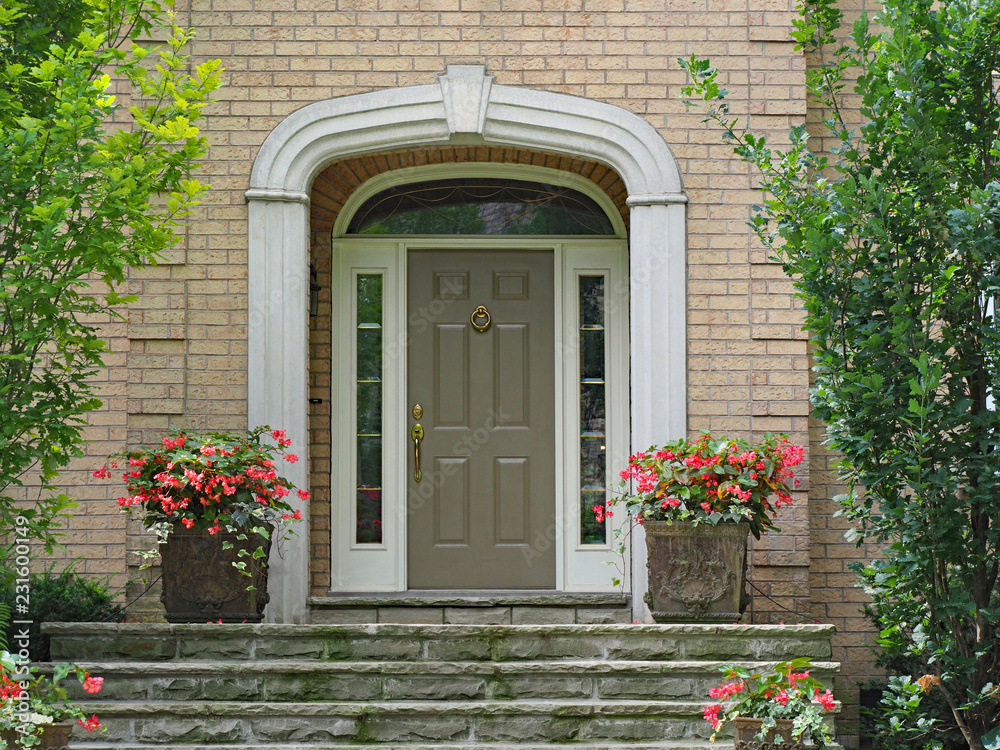 Fototapeta premium front door with sidelights and transom window, on brick house with stone steps