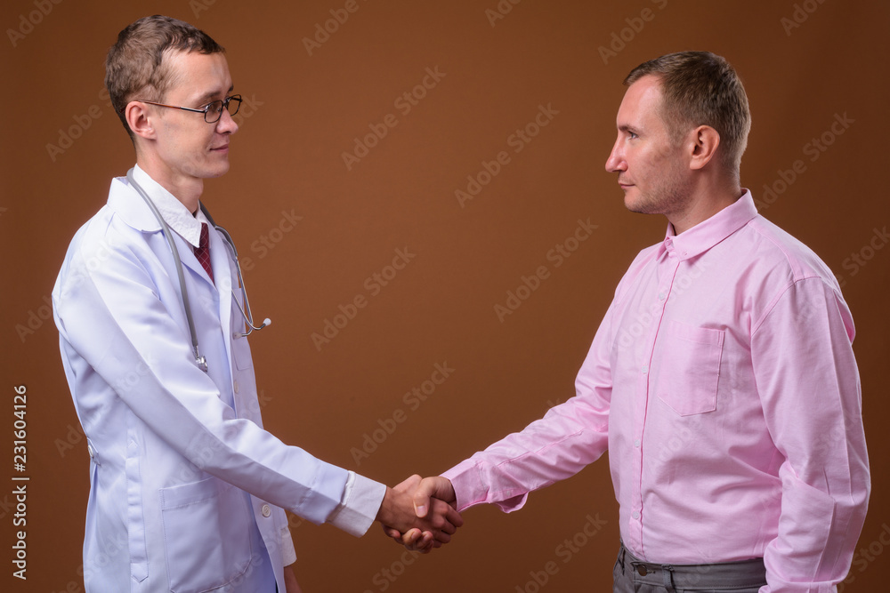 Young man doctor and man patient against brown background