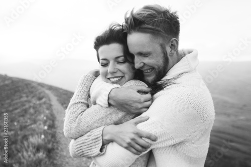Close-up portrait of man and woman together, happy, looking at each other. Smiling, kissing and laughing. Black and white toning