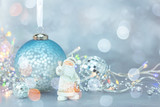christmas tree balls, garland lights and santa figurine on blue frosty background. christmas holidays decorations