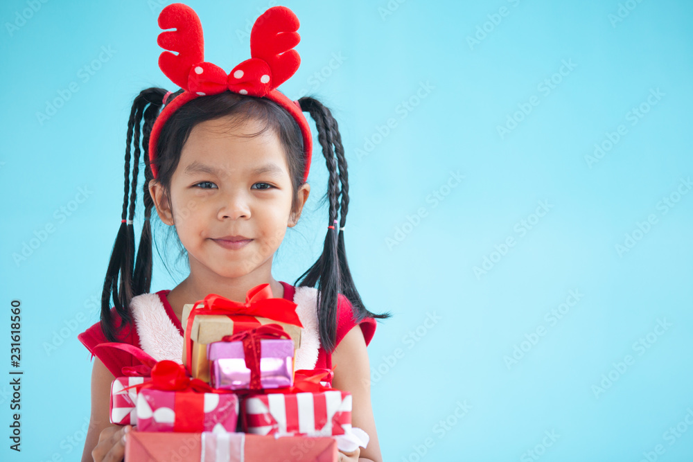 Cute asian child girl holding beautiful gift in hand on Christmas celebration Cute asian child girl holding beautiful gift in hand on Christmas celebration