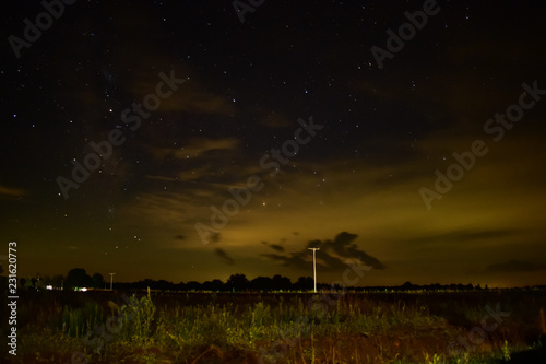 Cloudy Nightsky with stars shining bright. Rural country road.