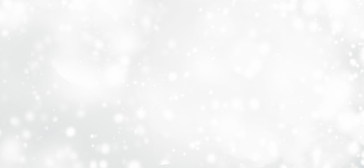 Silver  abstract bokeh background with snowflake and white glittering bokeh stars. A shiny holiday card. Glowing blurred lights.