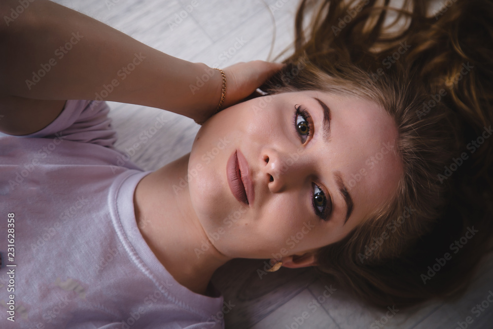 Girl in a white t-shirt lying on the floor Girl in a white t-shirt lying on the floor