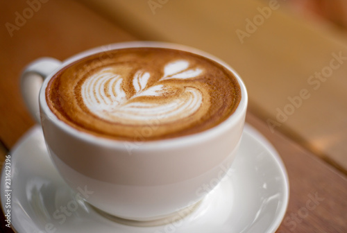 The hot coffee cup with smoke on the wooden table in the restaurant by retro style in the natural light. 