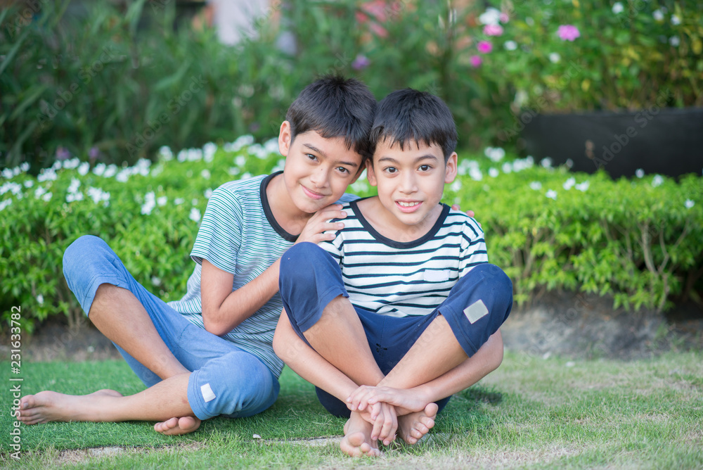 Asain Sibling boy sit togehter in the park