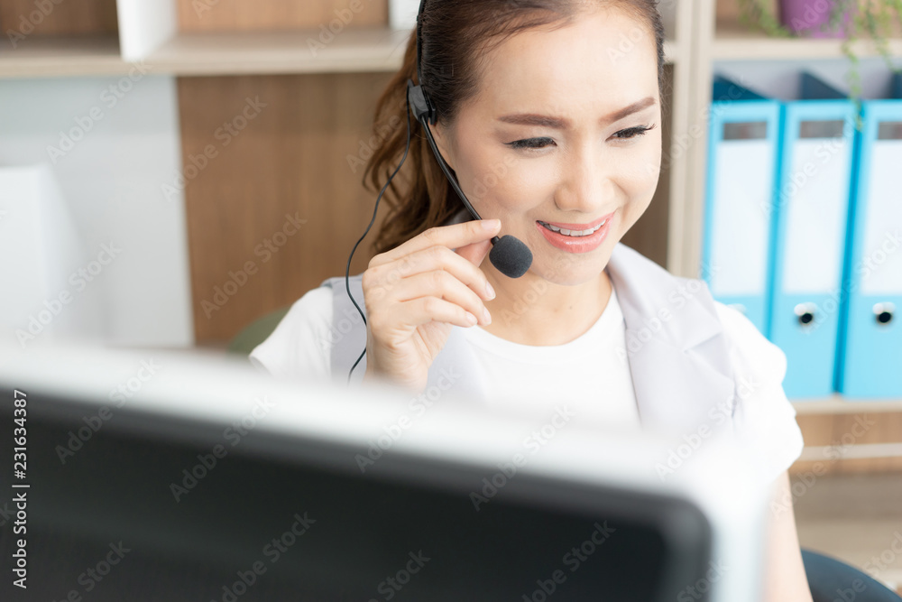 Beautiful Asian girl customer support with headset smiling during a telephone conversation Beautiful Asian girl customer support with headset smiling during a telephone conversation