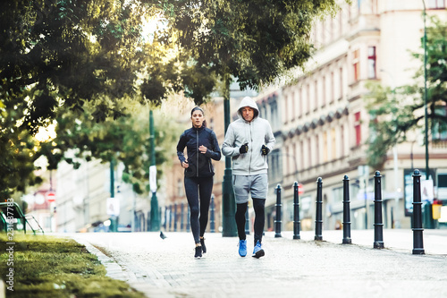 A fit couple running outdoors on the streets of Prague city.