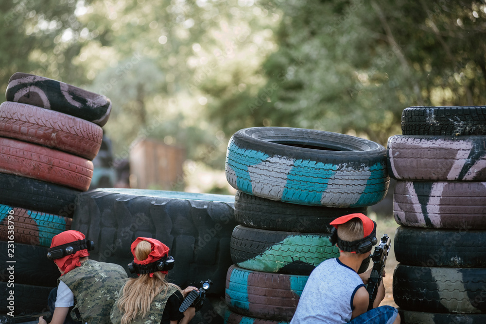 Obraz premium Kids playing lasertag on special polygon with shelter