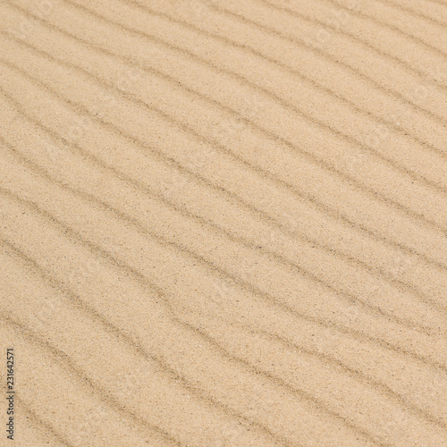 Diagonal waves of sand. Sandy texture background.