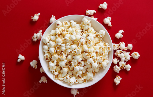 Popcorn in a white bowl against red background