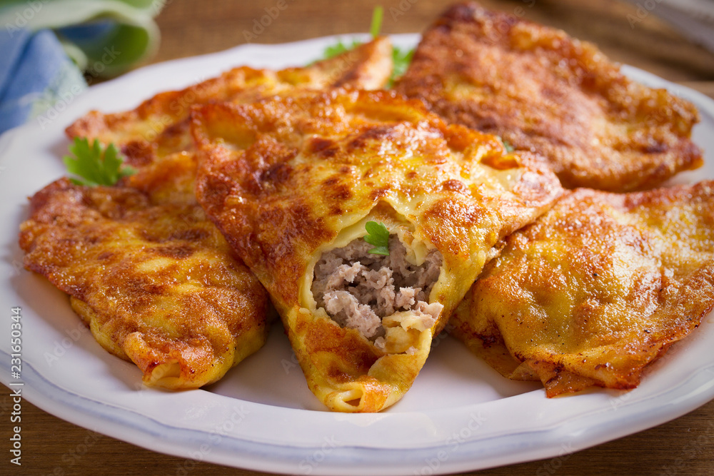 Savor crepes with meat filling. Crepes stuffed with beef sausage. horizontal