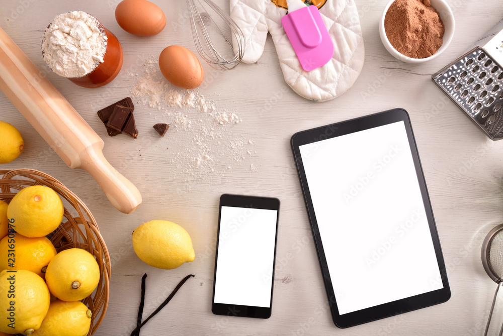 Pastry ingredients on white wooden table and mobile devices top Pastry ingredients on white wooden table and mobile devices top