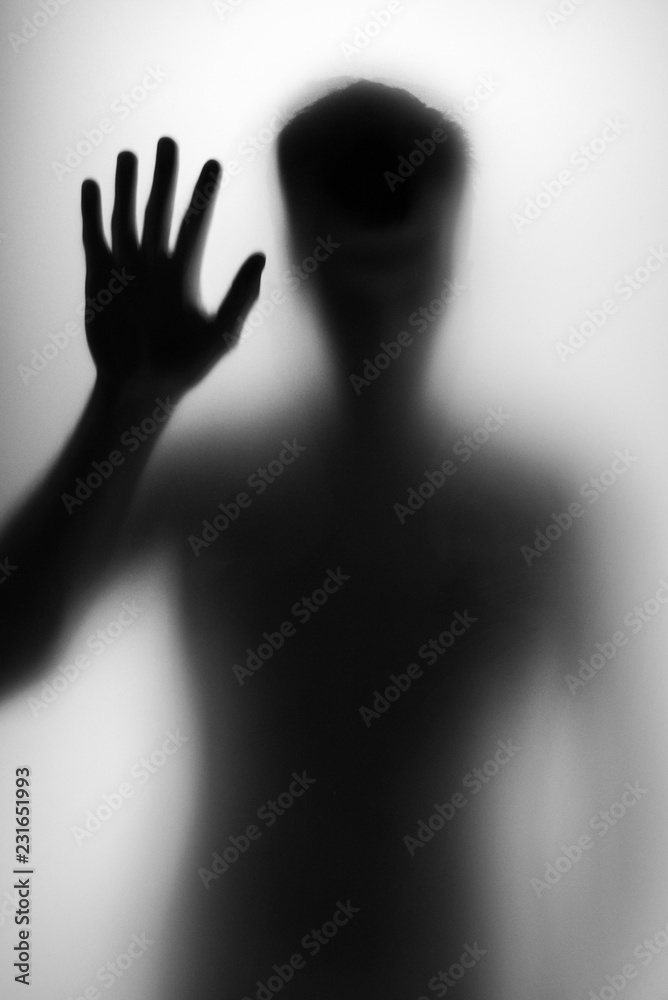 Man silhouette behind locked door Man silhouette behind locked door