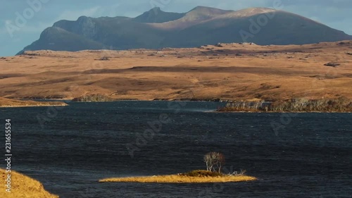 Ben Loyal in north Scotland, Sutherland, with cloud drifting across tops with deep blue loch in foreground. photo