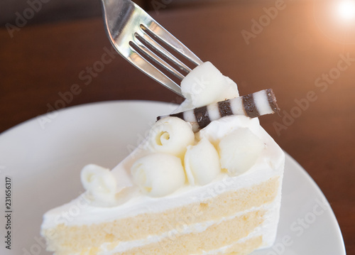 frok  cutting the Slice of cake in coffee shop