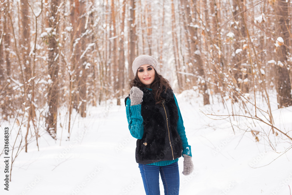 Young pretty woman walking in the winter snowy park at sunny day Young pretty woman walking in the winter snowy park at sunny day