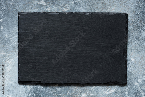 Black slate board on concrete background with copy space for text. Top view