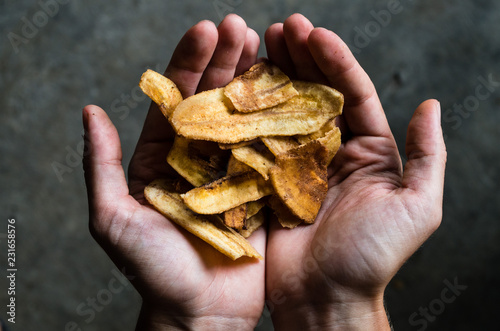 Two hands presenting delicious banana chips.