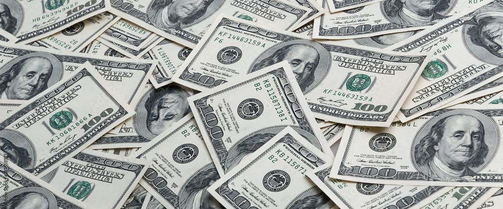 A background of scattered hundred dollar bills. A background of scattered hundred dollar bills.