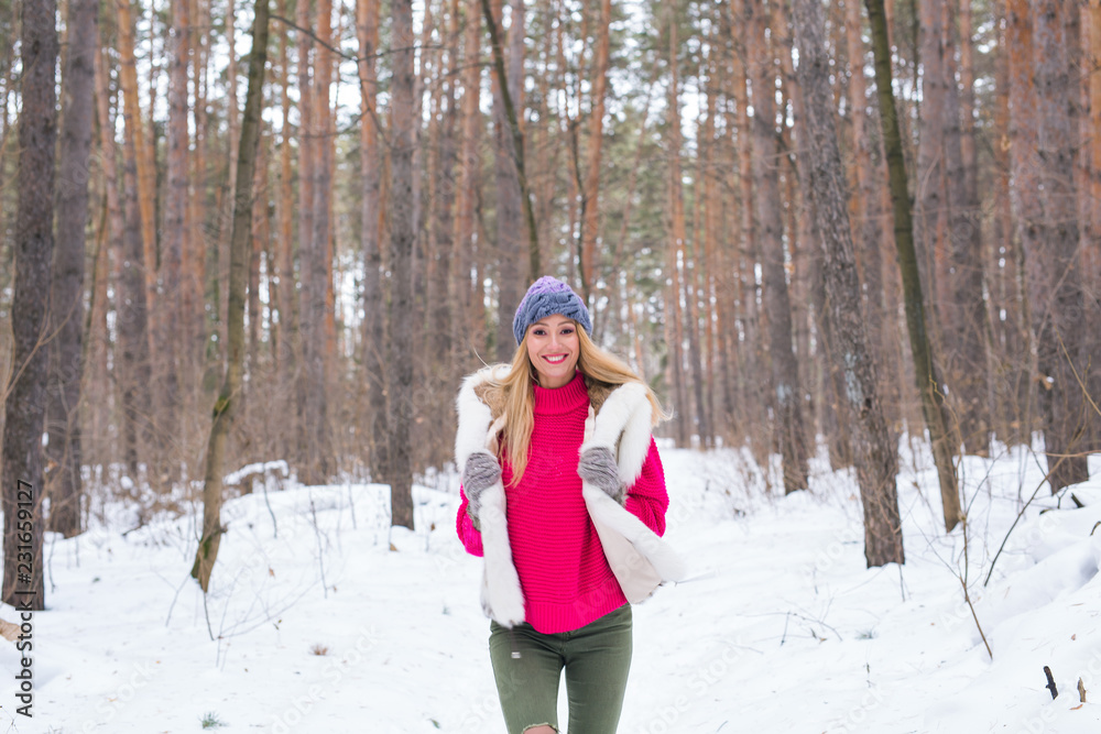 Season, nature, people concept - a beautiful blond woman running in winter wood and smiling Season, nature, people concept - a beautiful blond woman running in winter wood and smiling
