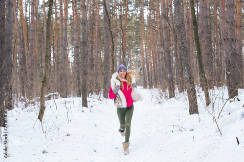 Nature and people concept - Portrait of running young blond woman in the winter park