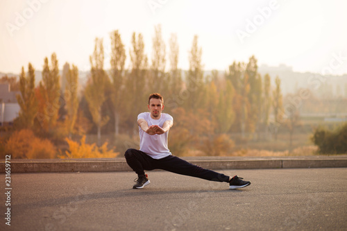 Young male jogger athlete training and doing workout outdoors
