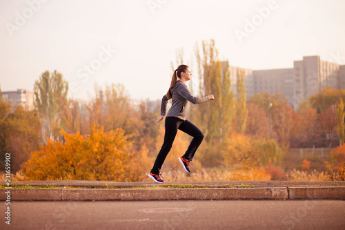 Woman running in autumn fall forest. Healthy concept