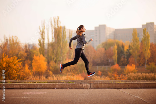 Woman running in autumn fall forest. Healthy concept