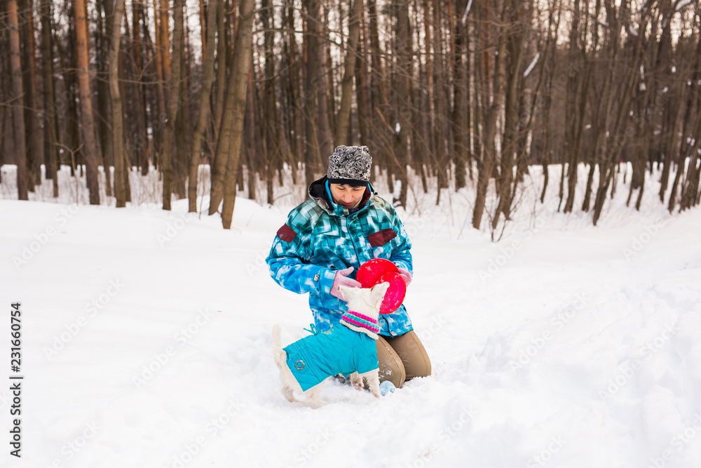 Pets owner and winter concept - Middle aged woman playing with her jack russell terrier dog in snowy park. Pets owner and winter concept - Middle aged woman playing with her jack russell terrier dog in snowy park.