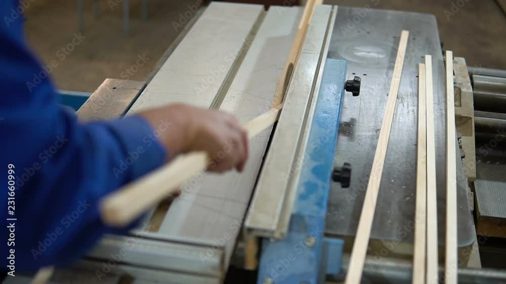 Carpenter at work at his workshop, wood processing on a woodworking machine Carpenter at work at his workshop, wood processing on a woodworking machine