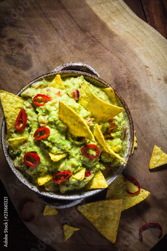 Bowl guacamole corn chips wooden table