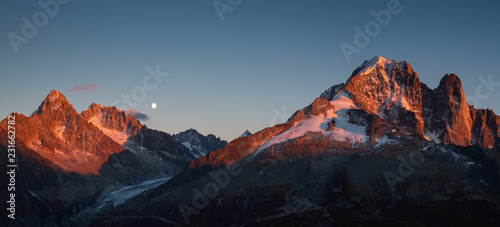 Panorama of the last sunlight on the mountain peaks near Chamonix, France, during moonrise.