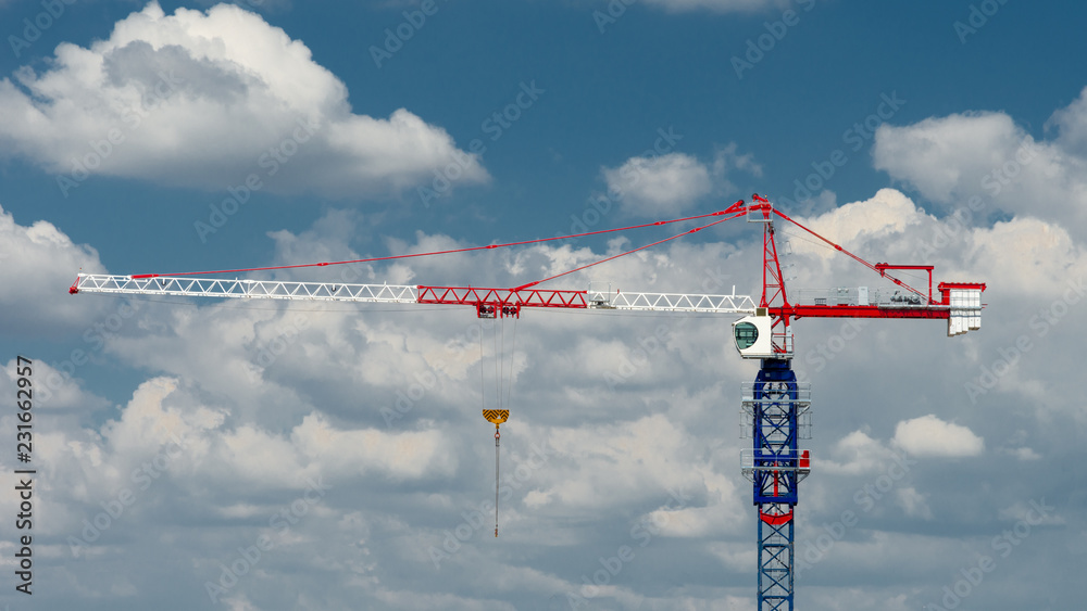 Tower crane on background of beautiful cloudy sky Tower crane on background of beautiful cloudy sky