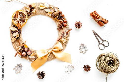 Christmas decoration concept. Creative christmas wreath made of thread near matherials and instruments, sciccors on white background top view