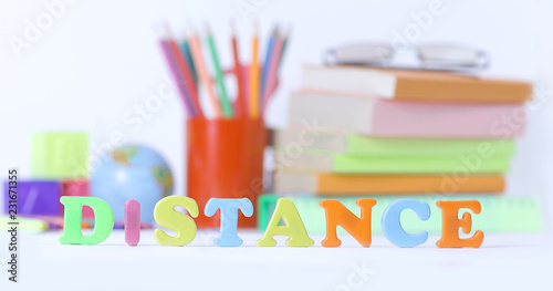 word distance on blurred background of school supplies .photo wi