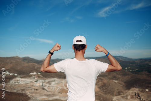 Young male rock climber on a cliff top photo