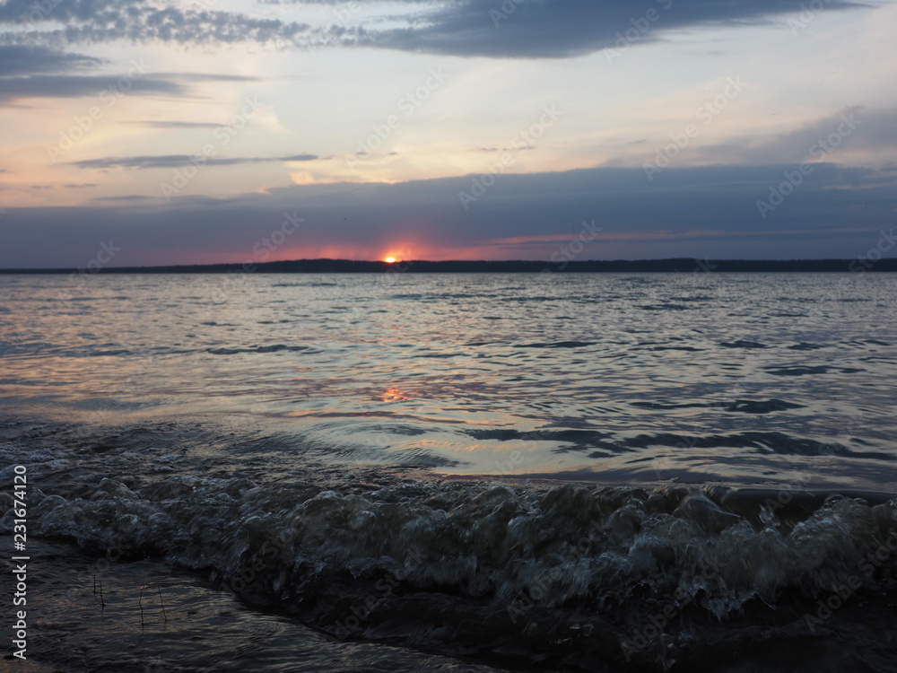 Obraz premium Sunset. On the big river. Coast. Beautiful clouds. Waves. Summer. Russia, Ural, Perm region