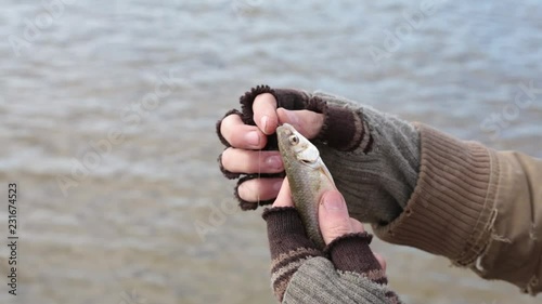 A bum caught a small fish by the bait, but it unexpectedly slips out of its hands.