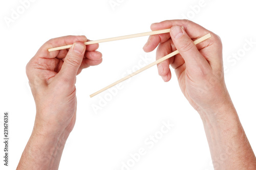 The elderly European man learns to hold bamboo Japanese chopsticks correctly. Isolated