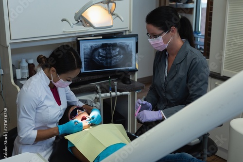 Female dentist examining patient in clinic photo